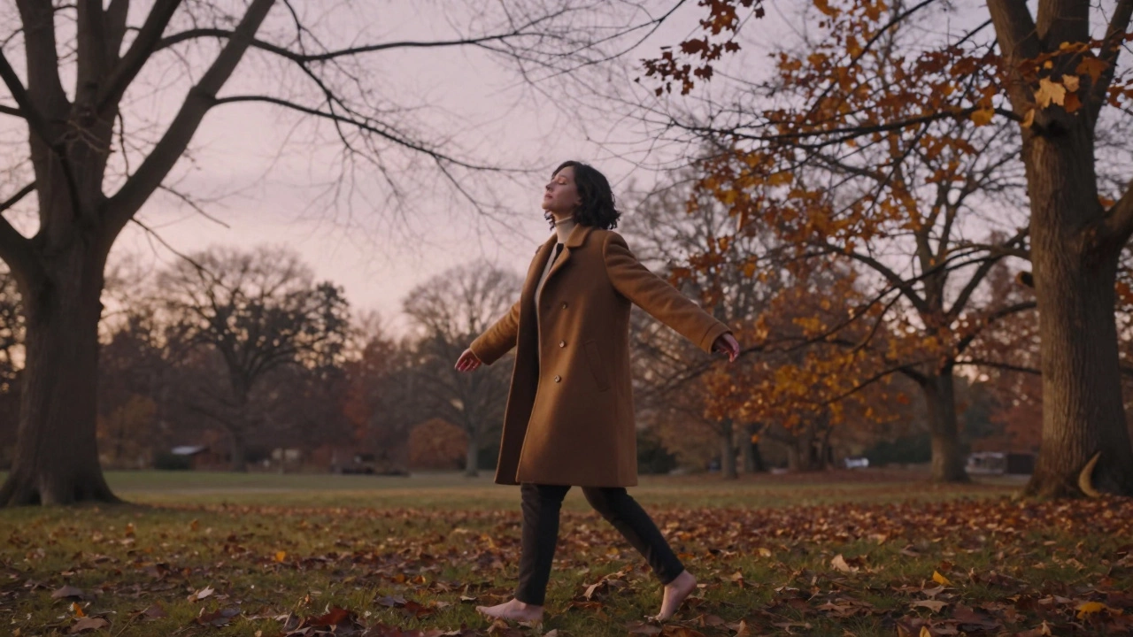 Someone walking barefoot through a quiet autumn park at sunset, eyes closed, fully present in nature.